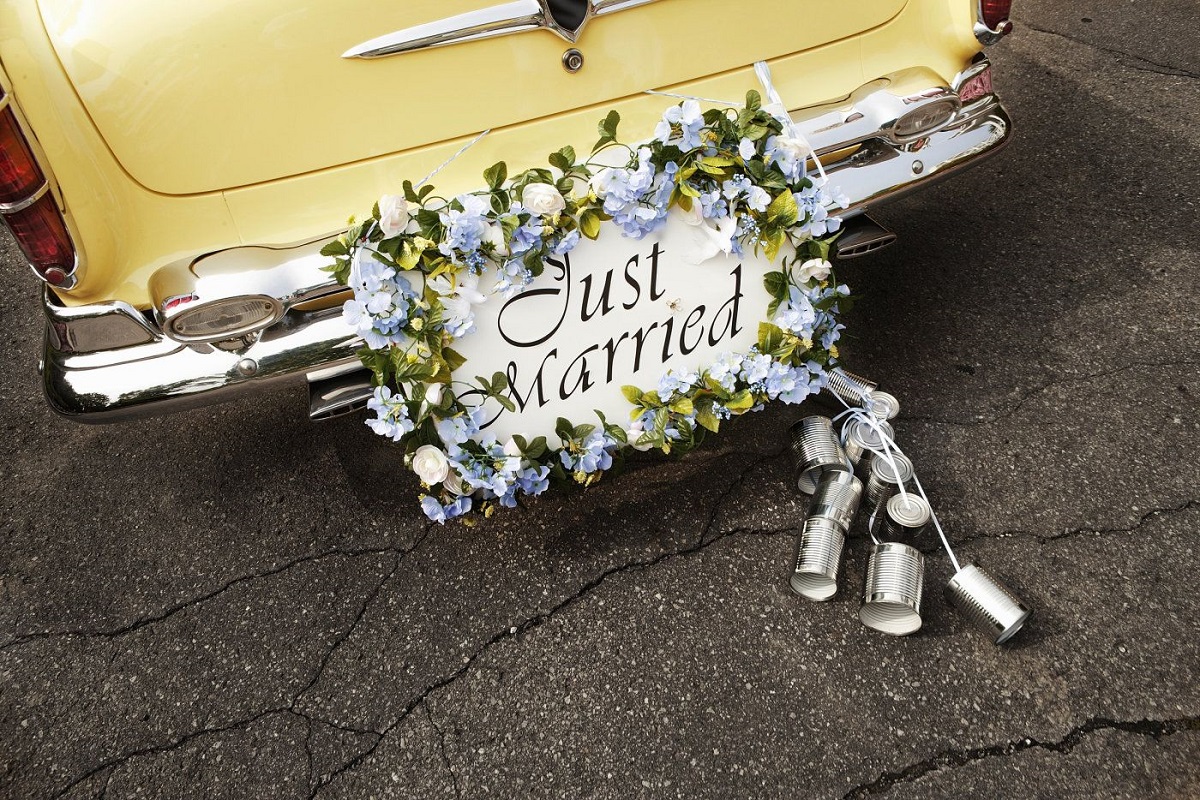 A string of tin cans behind the newlyweds' car